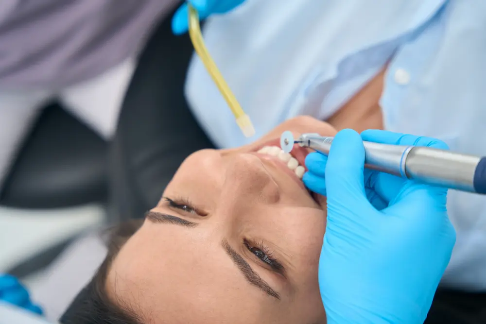 Dentist smoothing out patient teeth after a filling